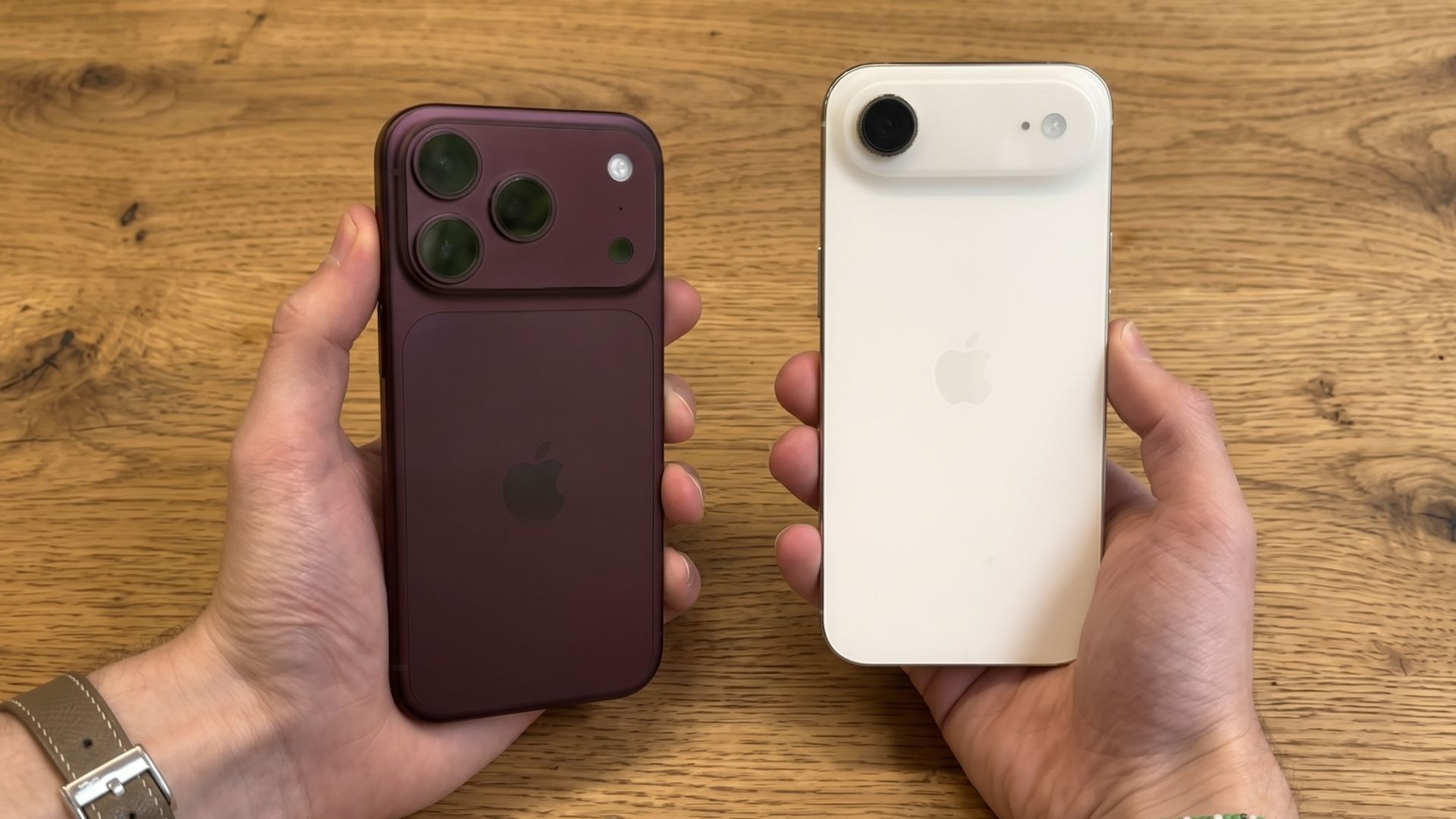 The iPhone 18 Pro and iPhone Air being held in opposite hands atop a wooden table