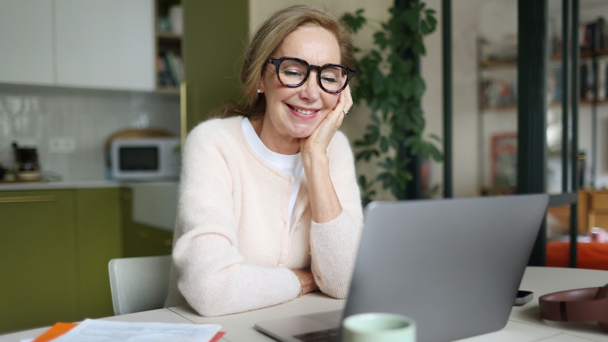 A woman smiling while working from home on her laptop