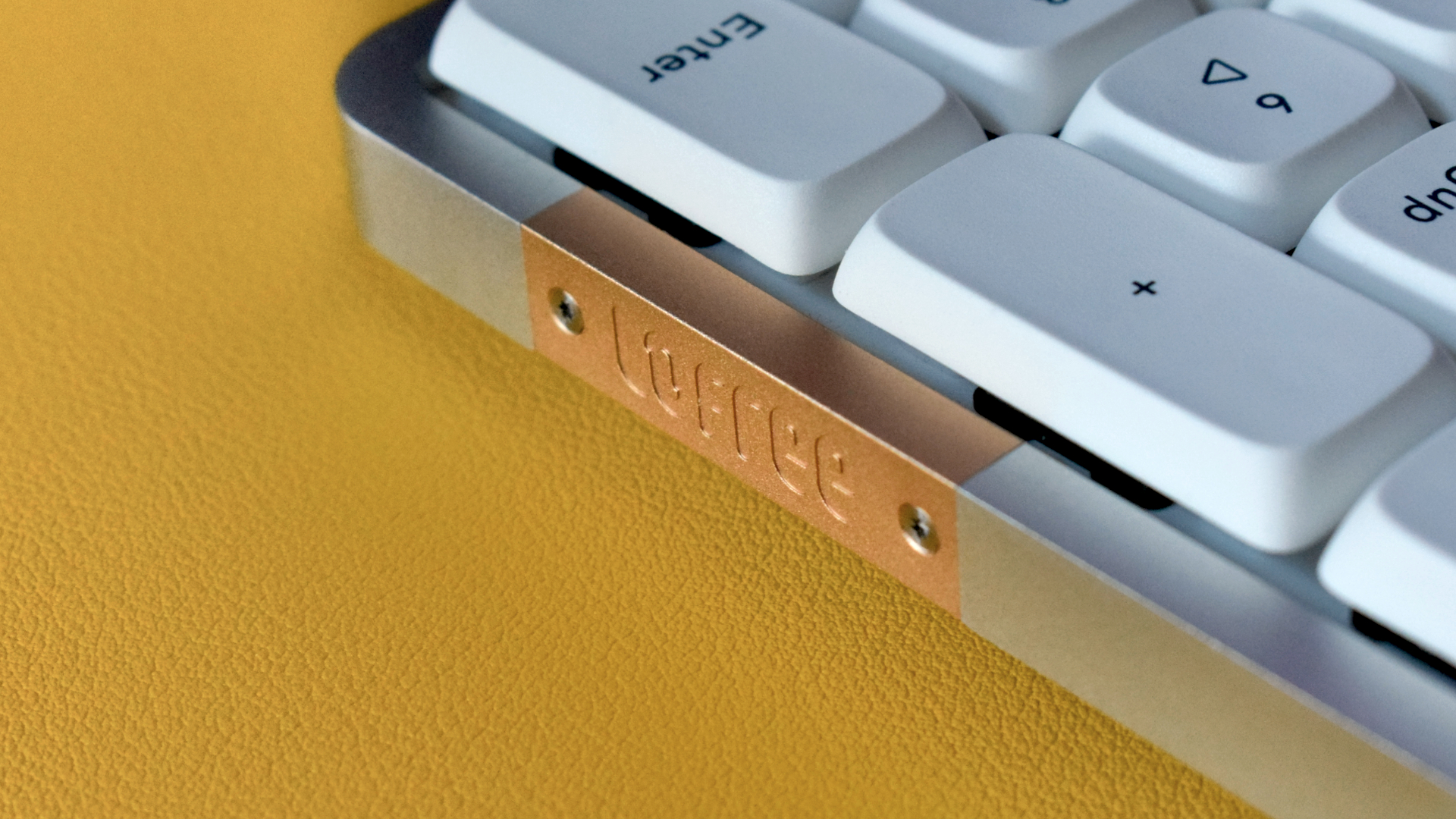 Lofree Flow mechanical wireless keyboard photograph showing gold/brass accented panel with Lofree branding on keyboard close up