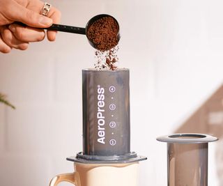 Ground coffee being poured into a AeroPress Original