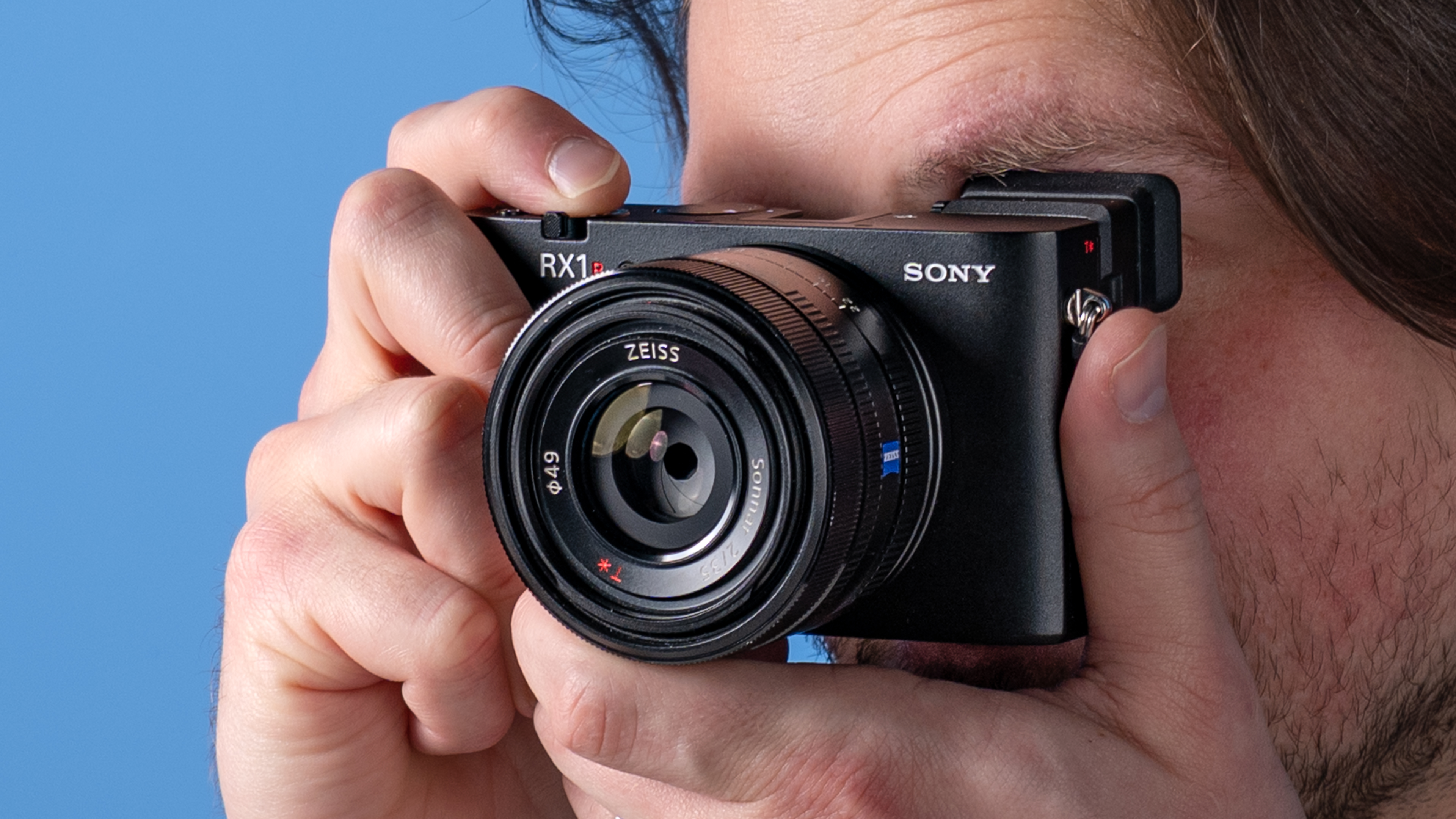 A photo of the Sony RX1R III in hand at a person's eye