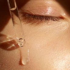 A woman applying serum to her skin