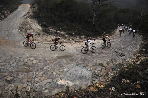 Riders fly downhill around a turn on stage 2 of the Brasil Ride