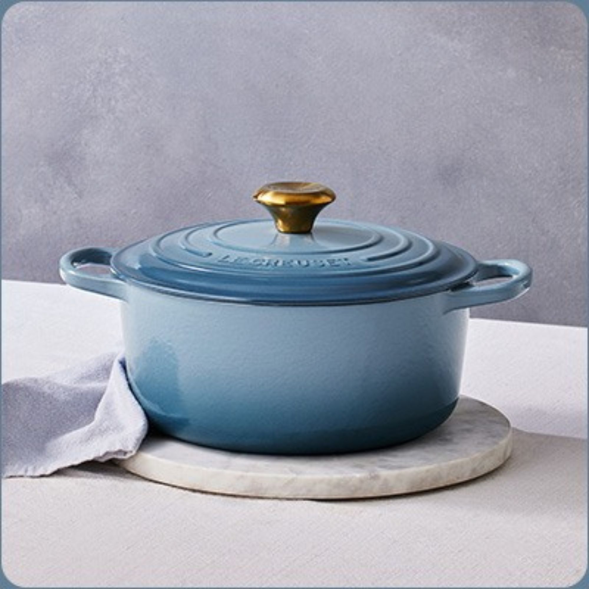 Le Creuset Signature Chambray Dutch Oven on a counter against a gray background. 