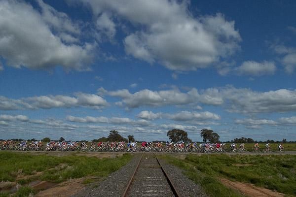The peloton crosses a railway line near Bunnaloo during stage three of the tour which began in fine conditions, something different to the previous tours so far this year.