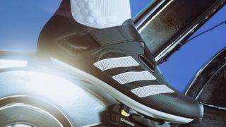 Person's foot wearing Adidas The Indoor Cycling Shoe clipped into spin bike pedal