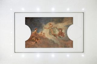 An old religious type painting in a white frame.