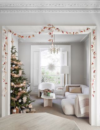 white living room with christmas tree and gold garlands