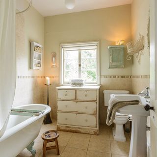bathroom with wash basin and chest of drawers with bathtub
