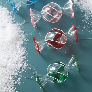 Handpainted Glass Candy Ornaments on a blue table.