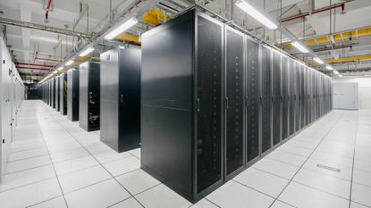 The inside of a brightly-lit supercomputer hall, representing exascale computing.