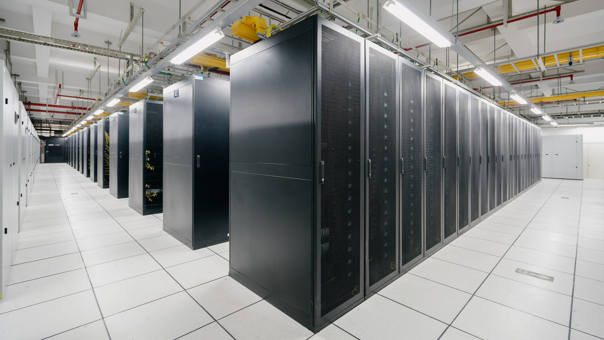 The inside of a brightly-lit supercomputer hall, representing exascale computing.