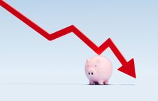 This image shows a red arrow line graph descending above a piggy bank, representing a decline in savings or financial performance.