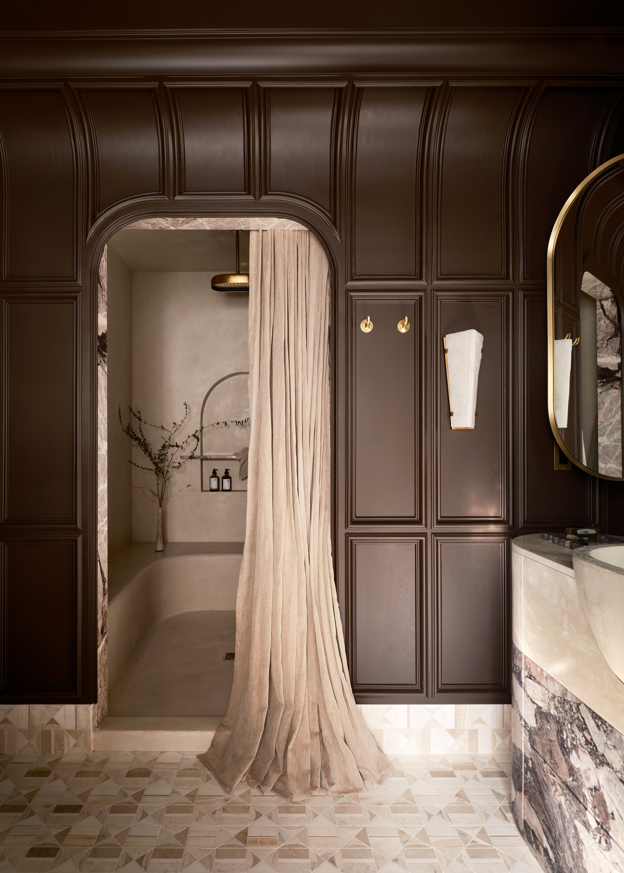 A bathroom with panelled walls painted a browny-purple and a walk-in shower with a shower curtain