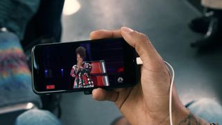 Someone watches The Voice on an iPhone on YouTube TV
