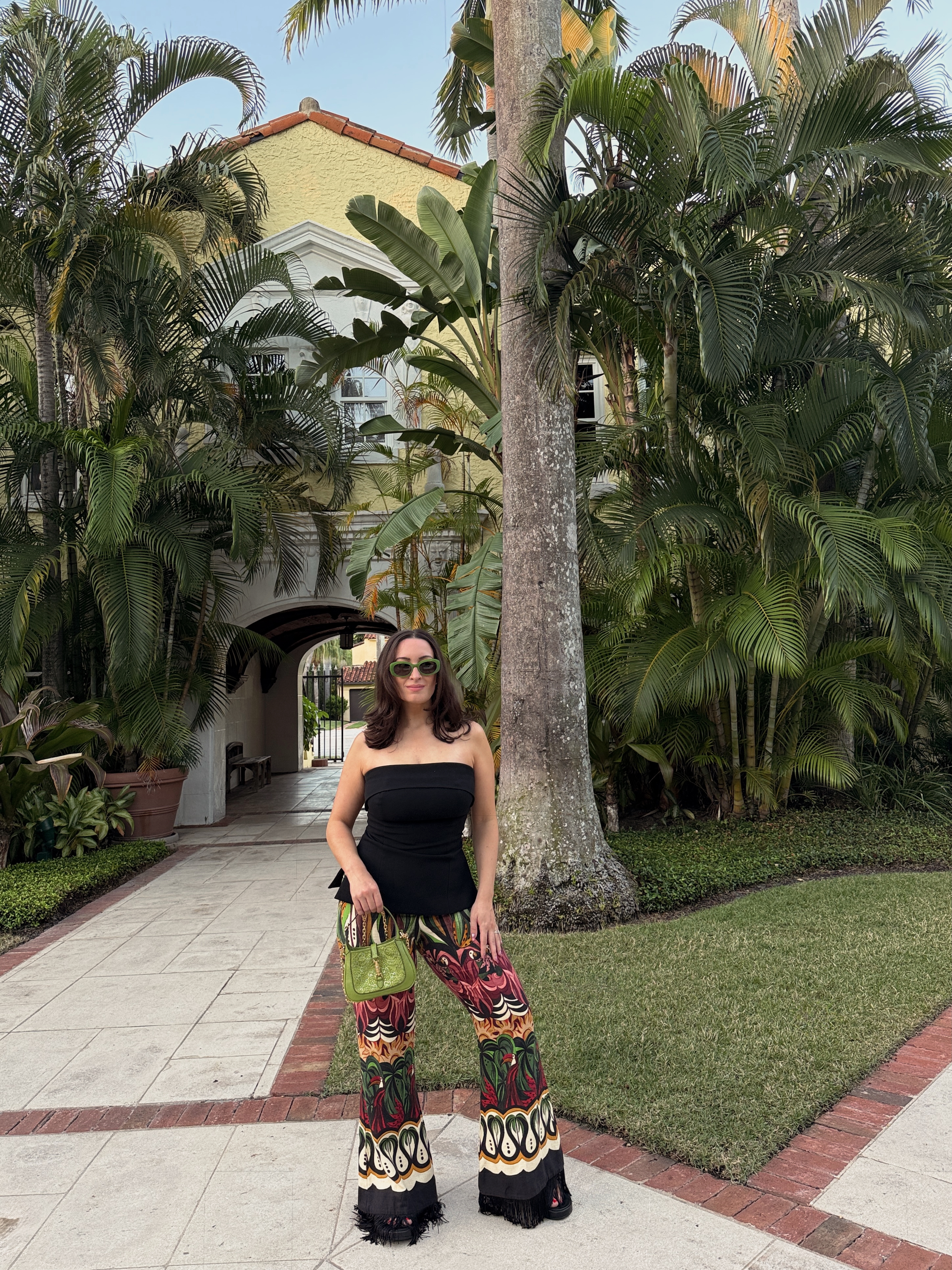 Bella Gerard wearing a black tube top and printed pants while on vacation in Florida