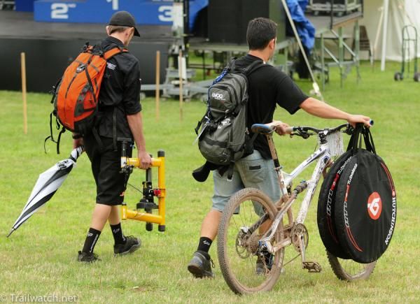 Support team with tools, spare wheels, trainer, and umbrella
