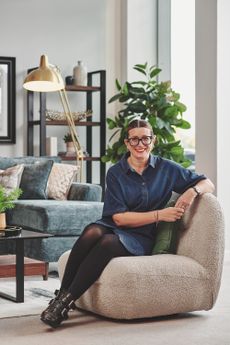 Heather Young sits within a corner of a Furniture Village store