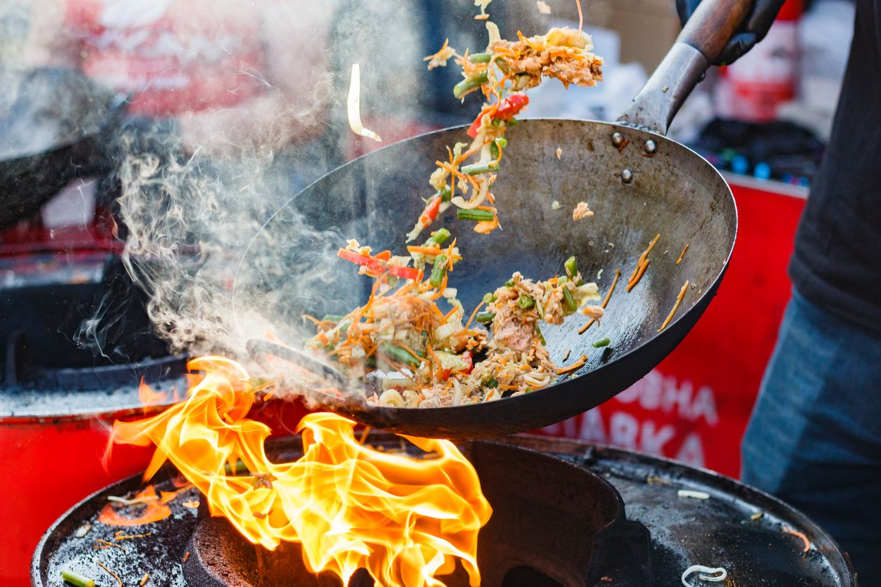 A person cooks outside.