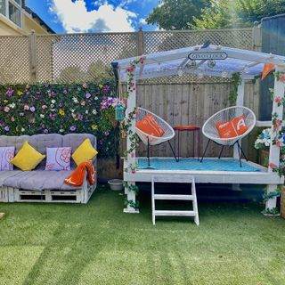 garden with floral wall and sofa set with cushion