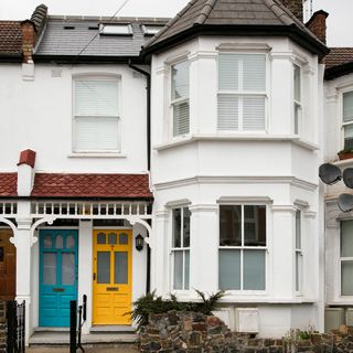 house with white wall and sky blue and yellow door