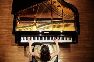 Overhead shot of woman playing a grand piano