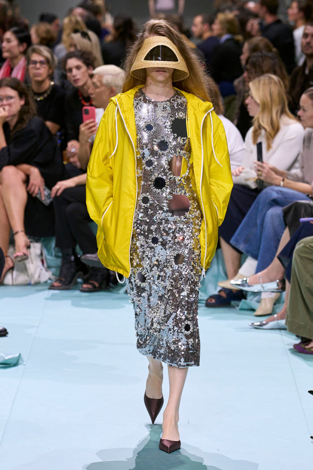 Women in yellow rain coat and silver dress.