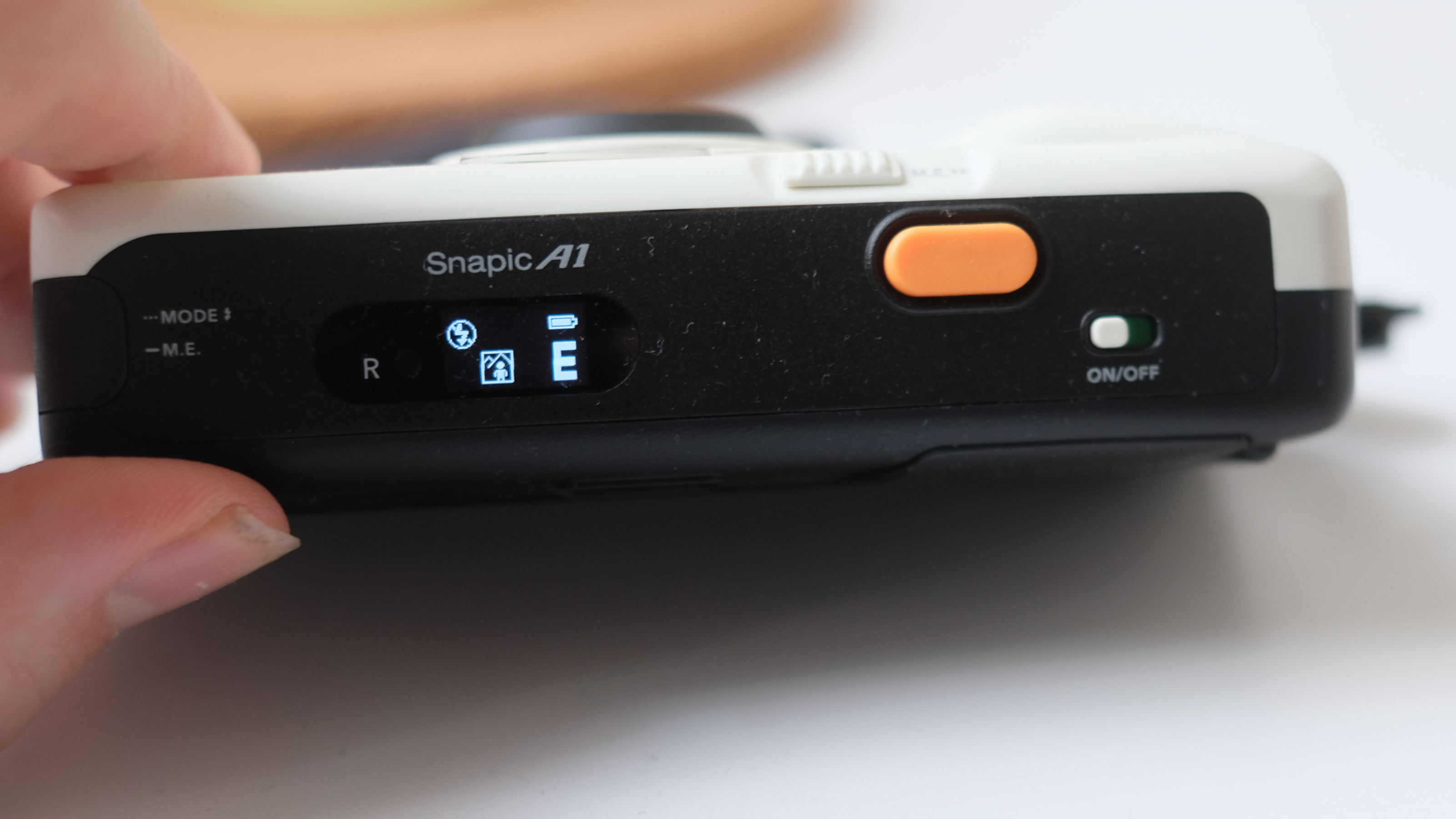 Photograph of Kodak Snapic A1 point-and-shoot film camera showing top LCD screen with shot counter and orange shutter button