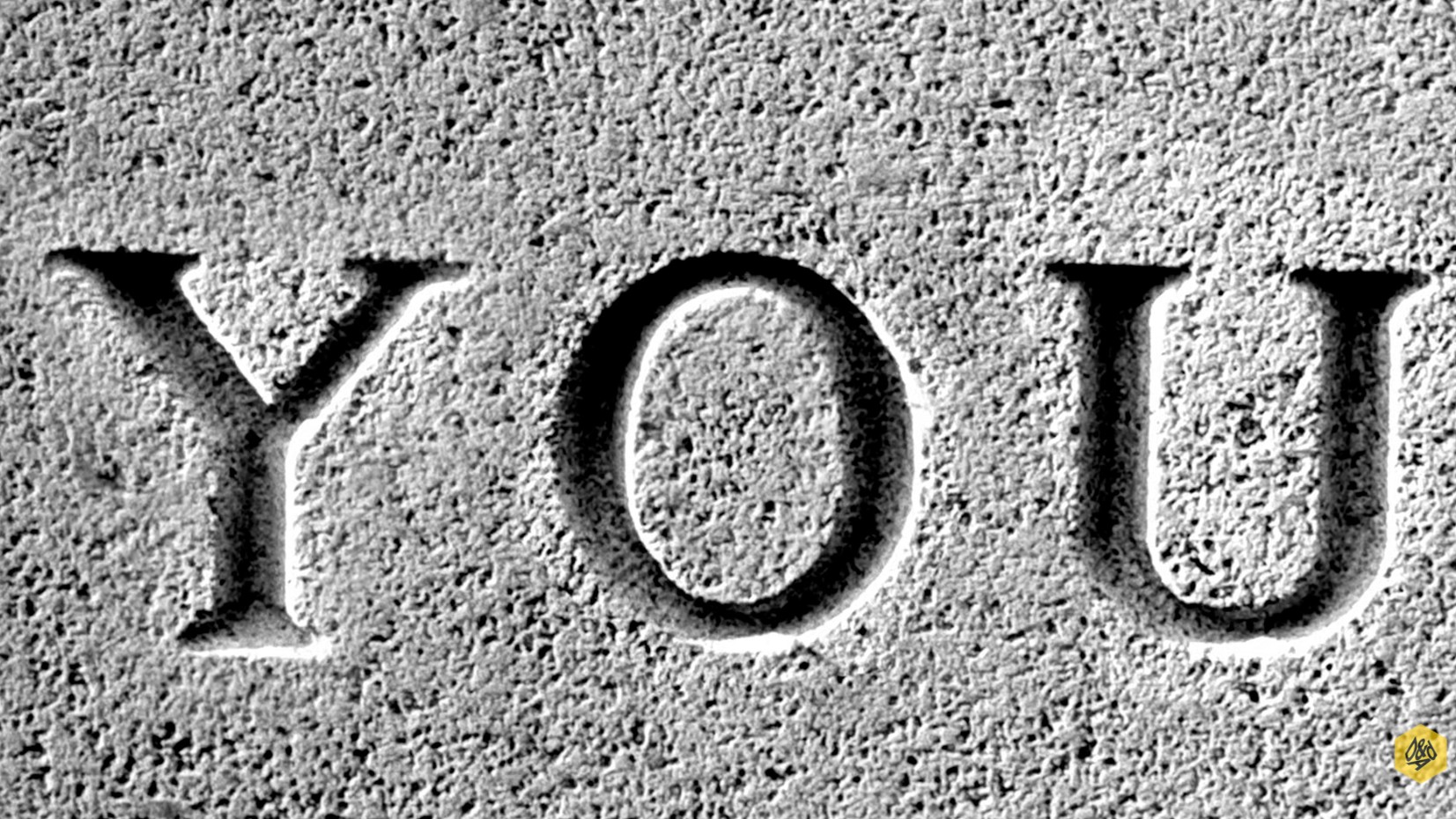 Close-up, black and white image of the word 'YOU' carved into a rough, grainy stone surface, resembling a tombstone or ancient monument