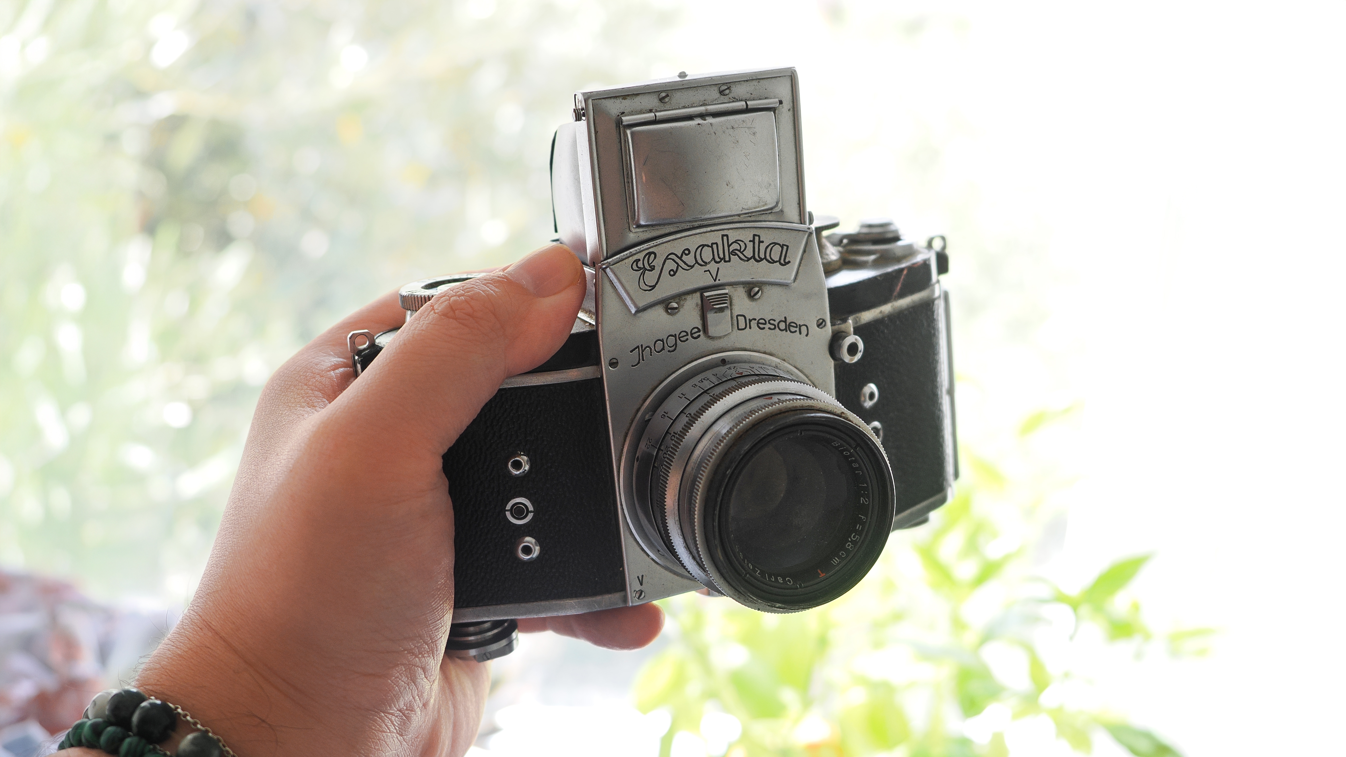 Exakta V being held in up front of greenery