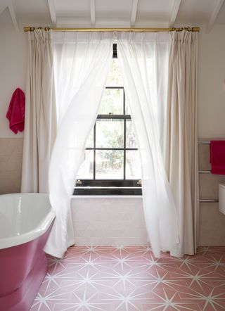 light and airy bathroom with pink floor and light curtains