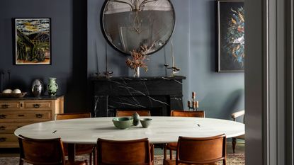 Dining room with fireplace and circular mirror and walls painted in Farrow &amp; Ball Down Pipe