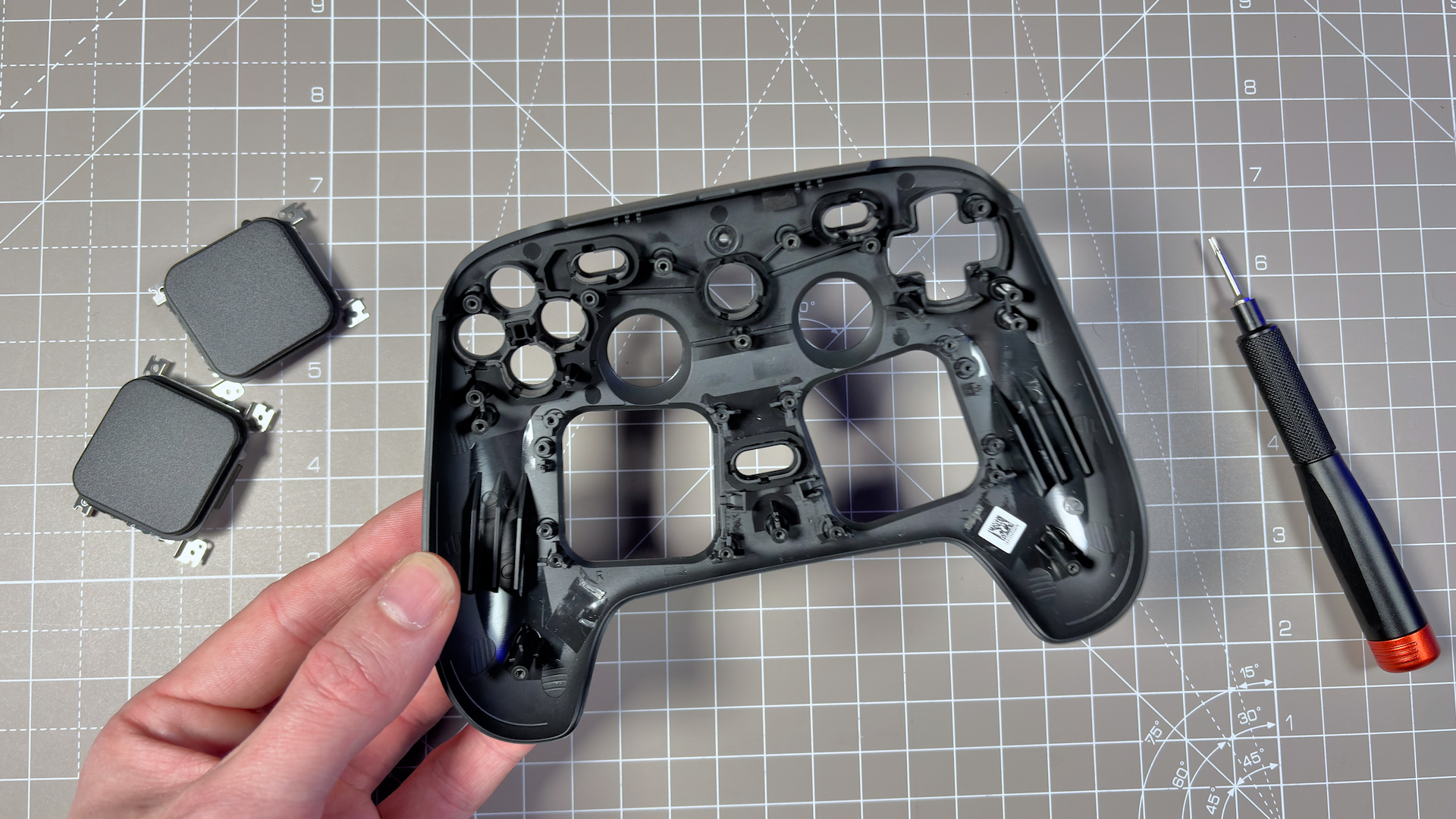 The Steam Controller on a desk during a teardown, with various parts removed.