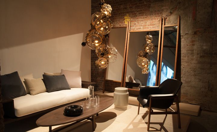 View of grey, cream an brown living room with seating and gold low hanging chandelier