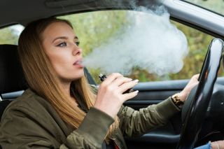 woman vaping in her car