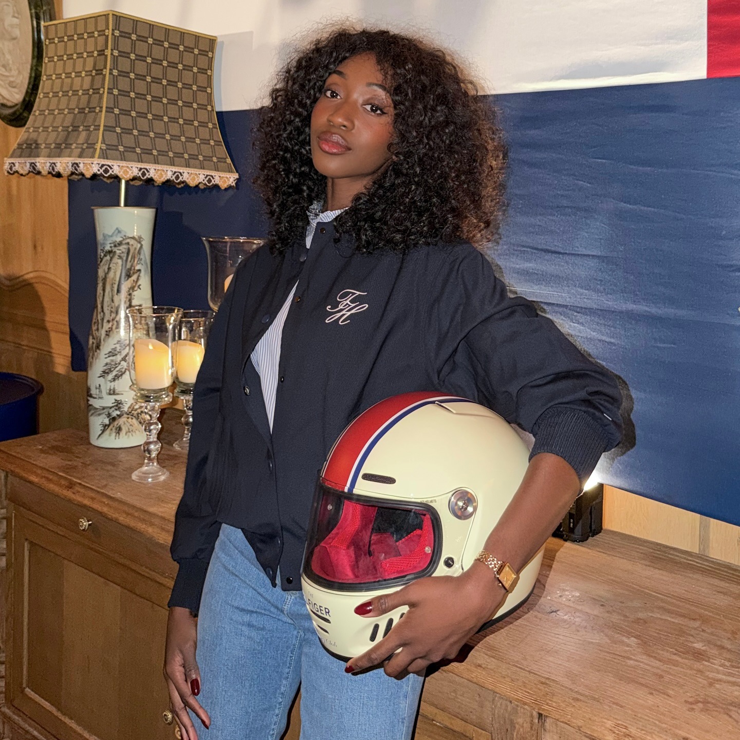 Woman in a sporty jacket and button-down shirt with jeans.