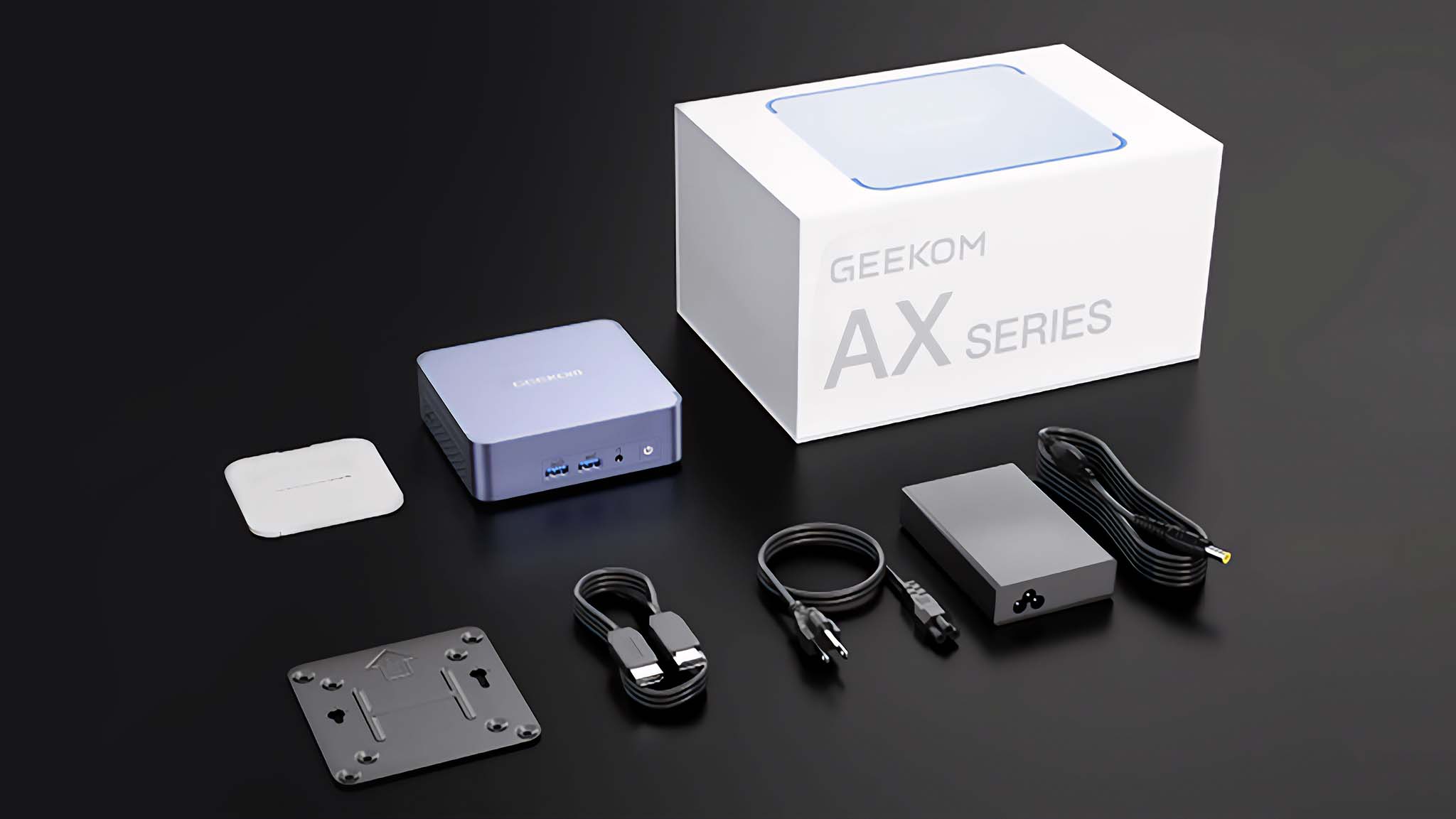 Geekom AX7 Pro along with a manual, VESA mount, power cable, and HDMI cable. 