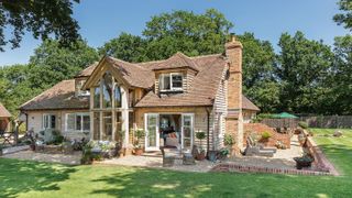 traditional oak frame house surrounded by a large patio and lawn area