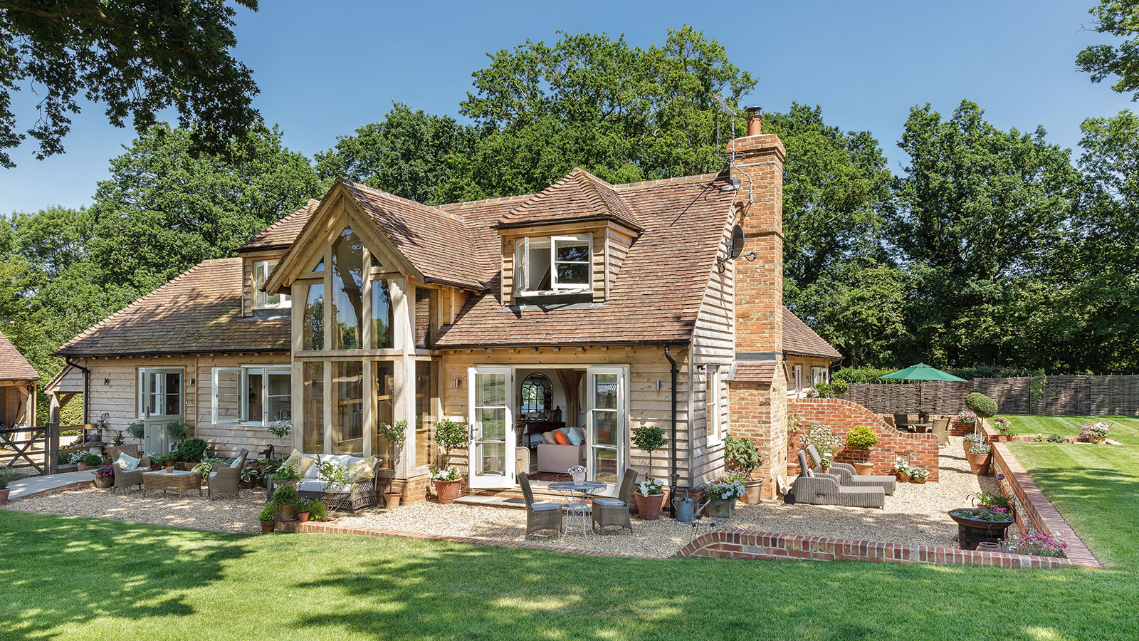 traditional oak frame house surrounded by a large patio and lawn area