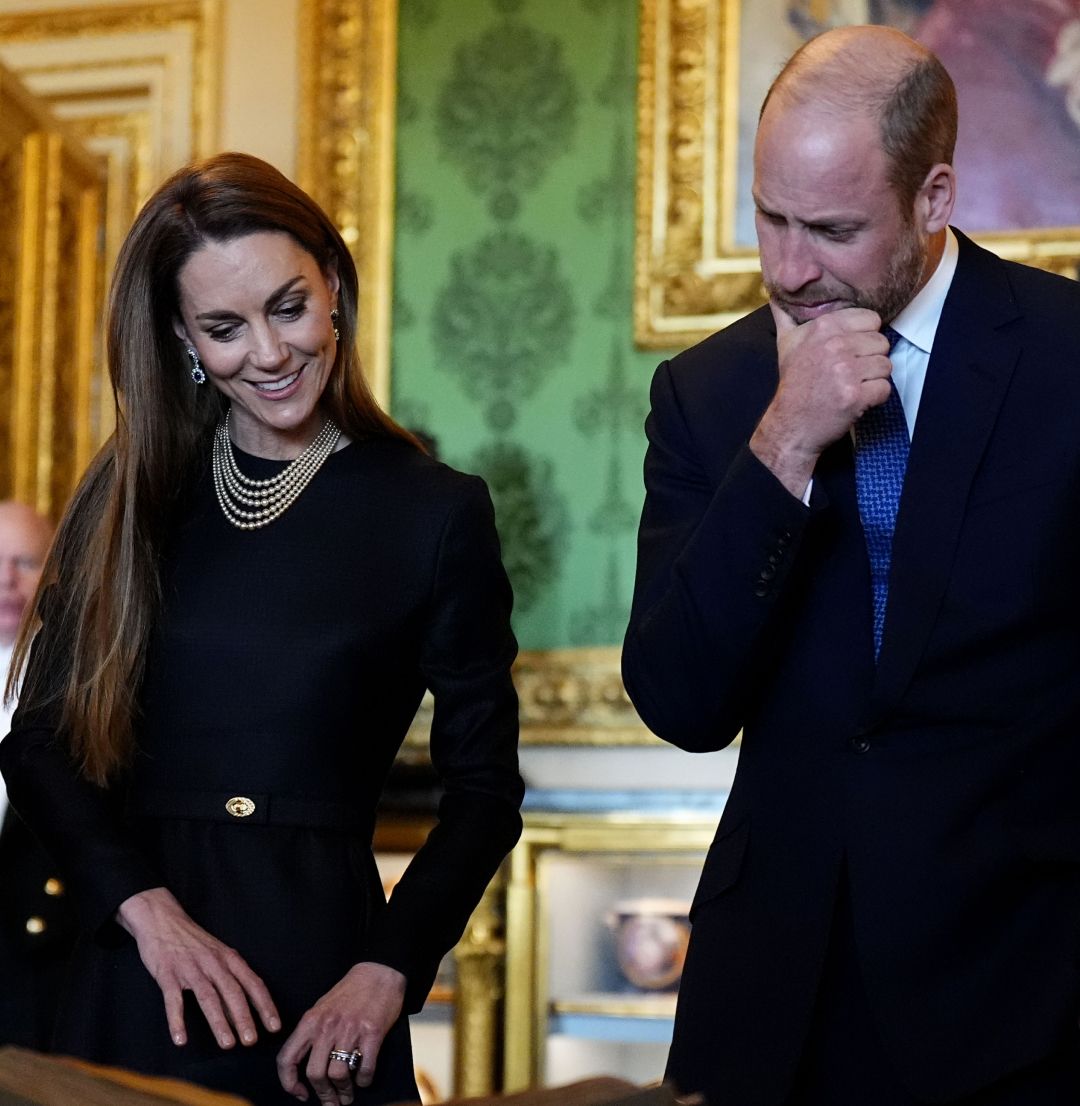 Prince William and Kate Middleton looking down at artwork
