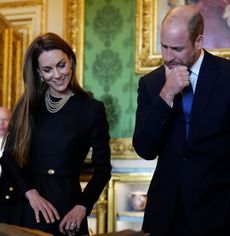Prince William and Kate Middleton looking down at artwork