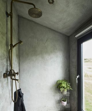 A wet room with green textured paint and bathroom shelving