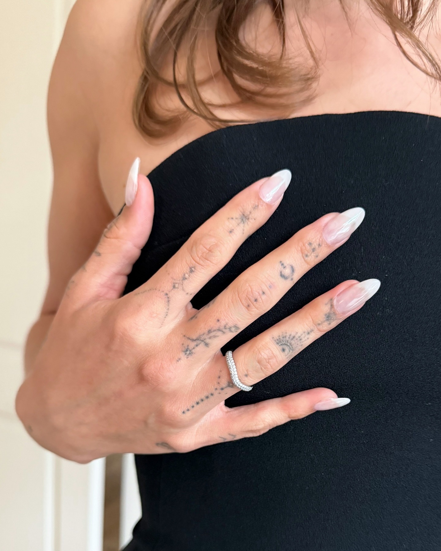 Close up of Hailey Bieber's nails with milky French manicure with OPI Funny Bunny and chrome powder