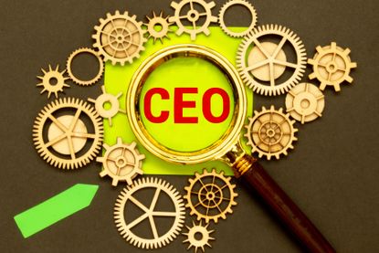 the word CEO on a post it note surrounded by gears and under a magnifying glass