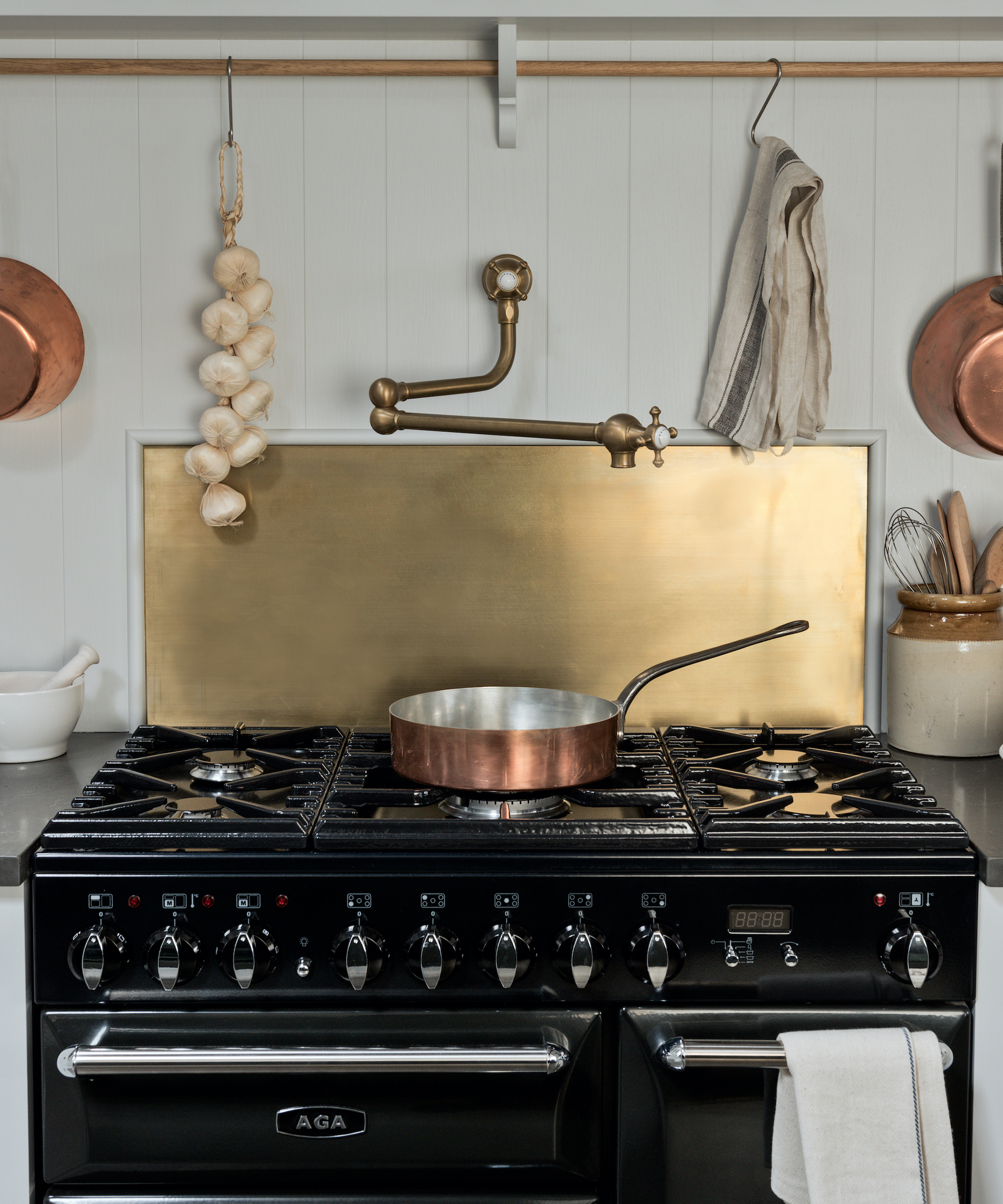 black cooker with brass backsplash
