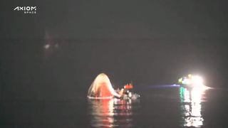 SpaceX Dragon capsule with recovery teams after splashdown.