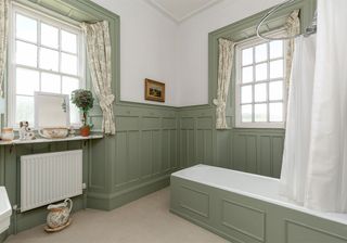 bathroom with slim bathtub and large white window