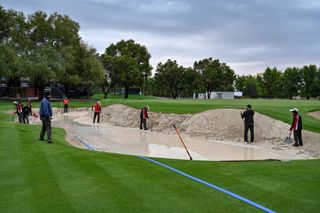 Greenkeepers working on a bunker that was damaged by the rain