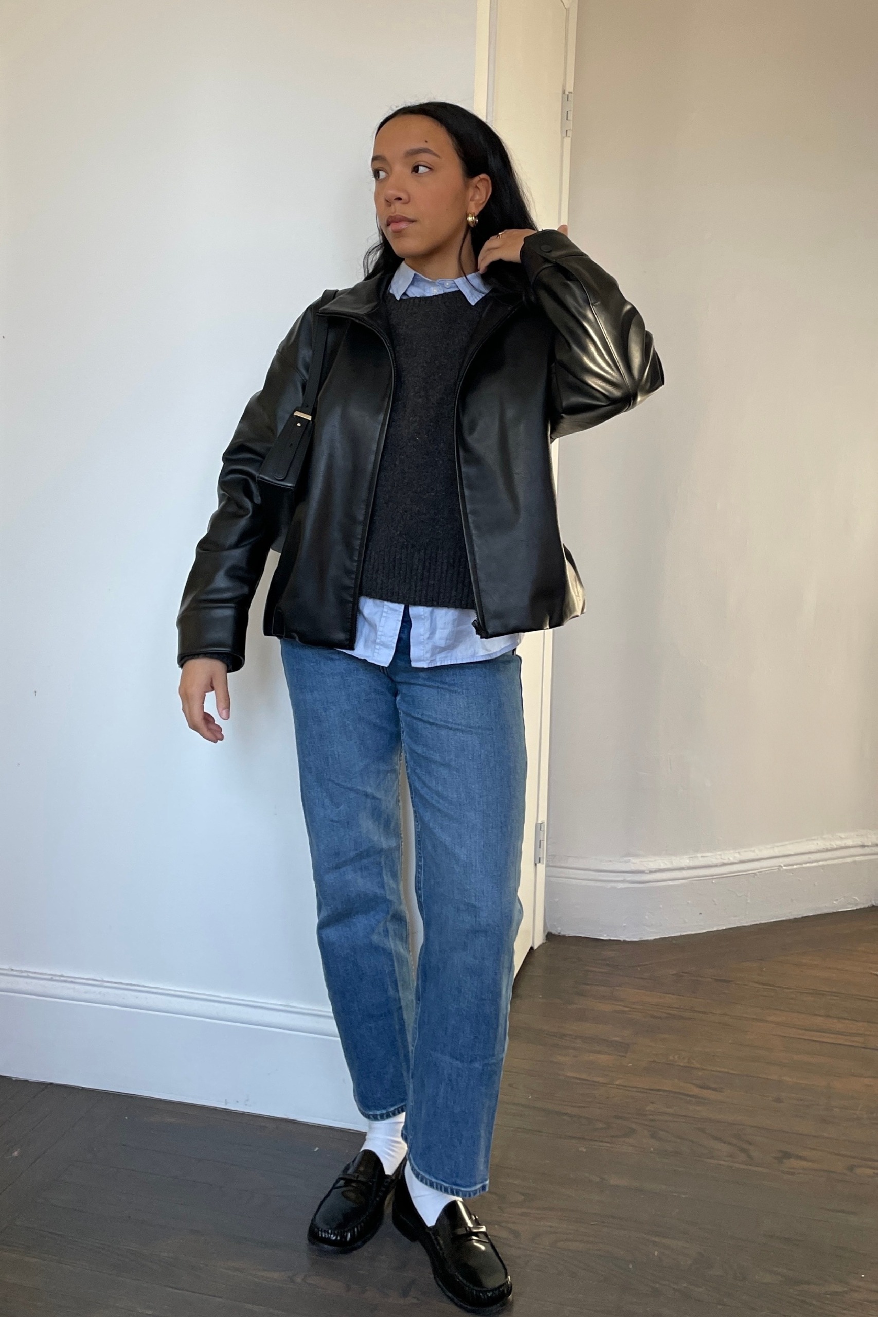 Lauren Tappan wearing cigarette jeans, a leather jacket, a sweater, and a button-down