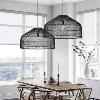 Two large rattan light fixtures hanging above a dining room table
